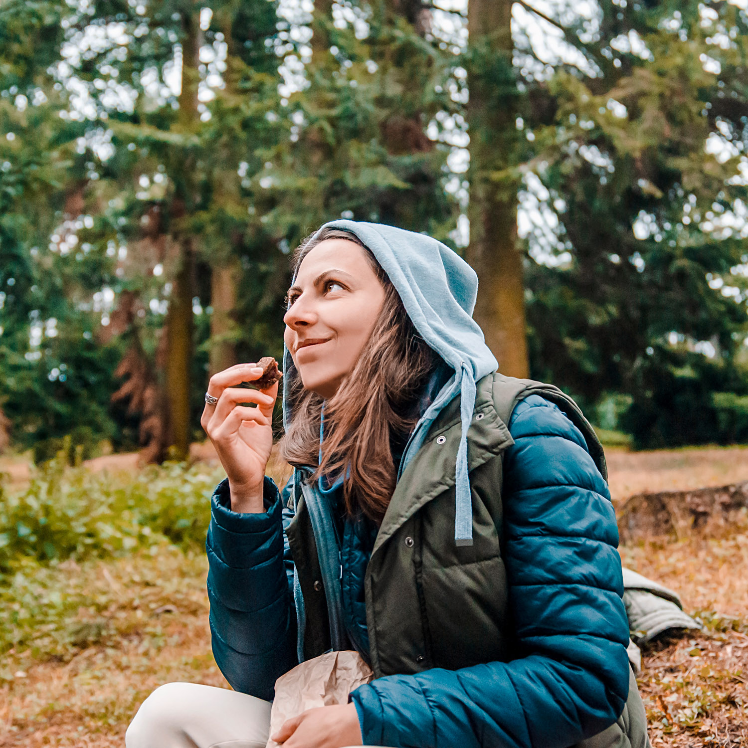Frau macht Pause im Wald und isst