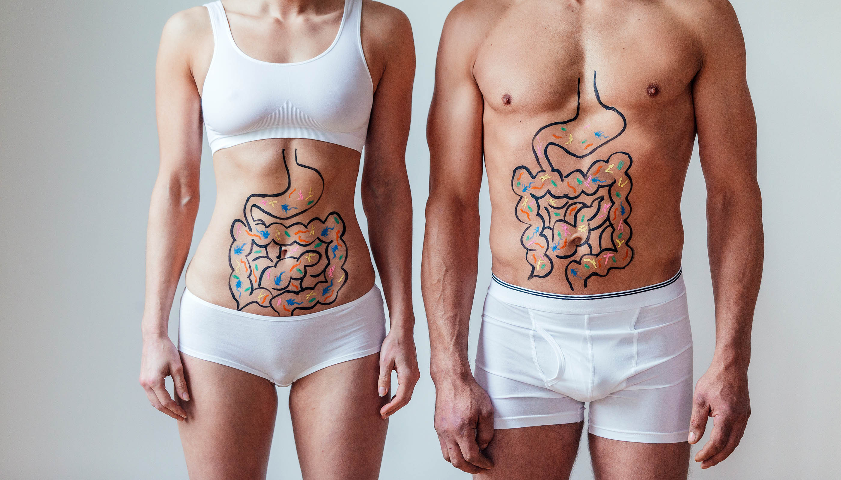 Frau und Mann stehen in Unterwäsche zur Kamera und haben den Magen-Darm-Trakt aufgemalt