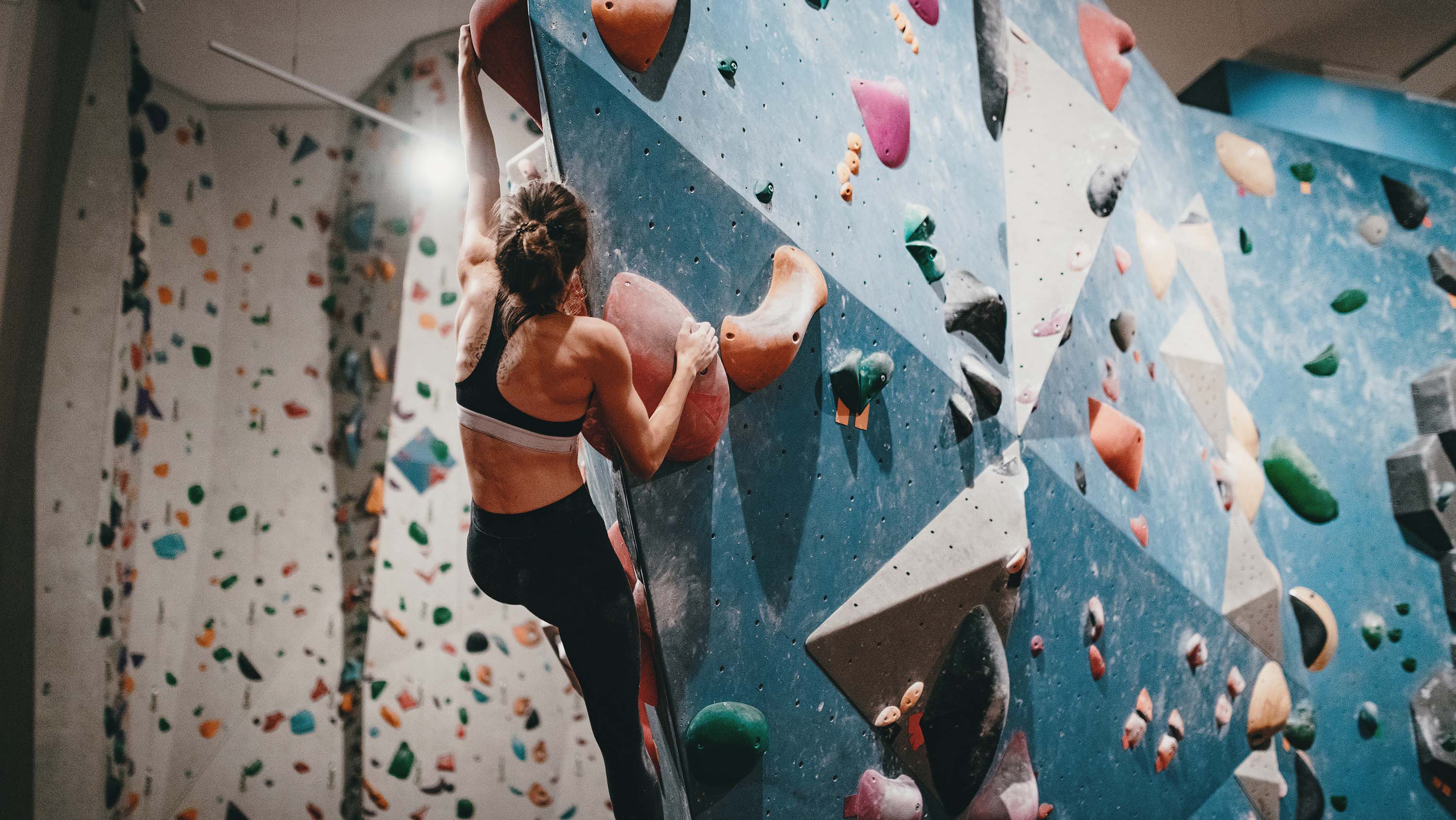 Frau klettert in Boulderhalle